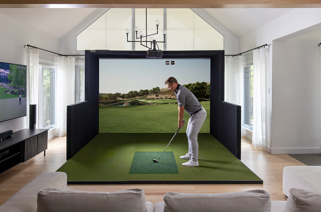 Man playing golf on a virtual reality simulator in a modern living room.