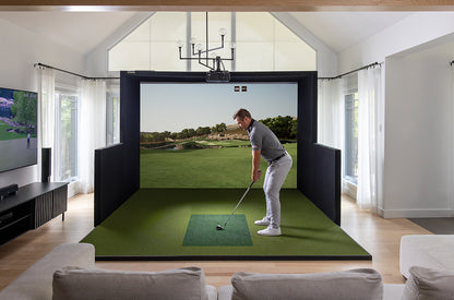 Man playing golf on a virtual reality simulator in a modern living room.